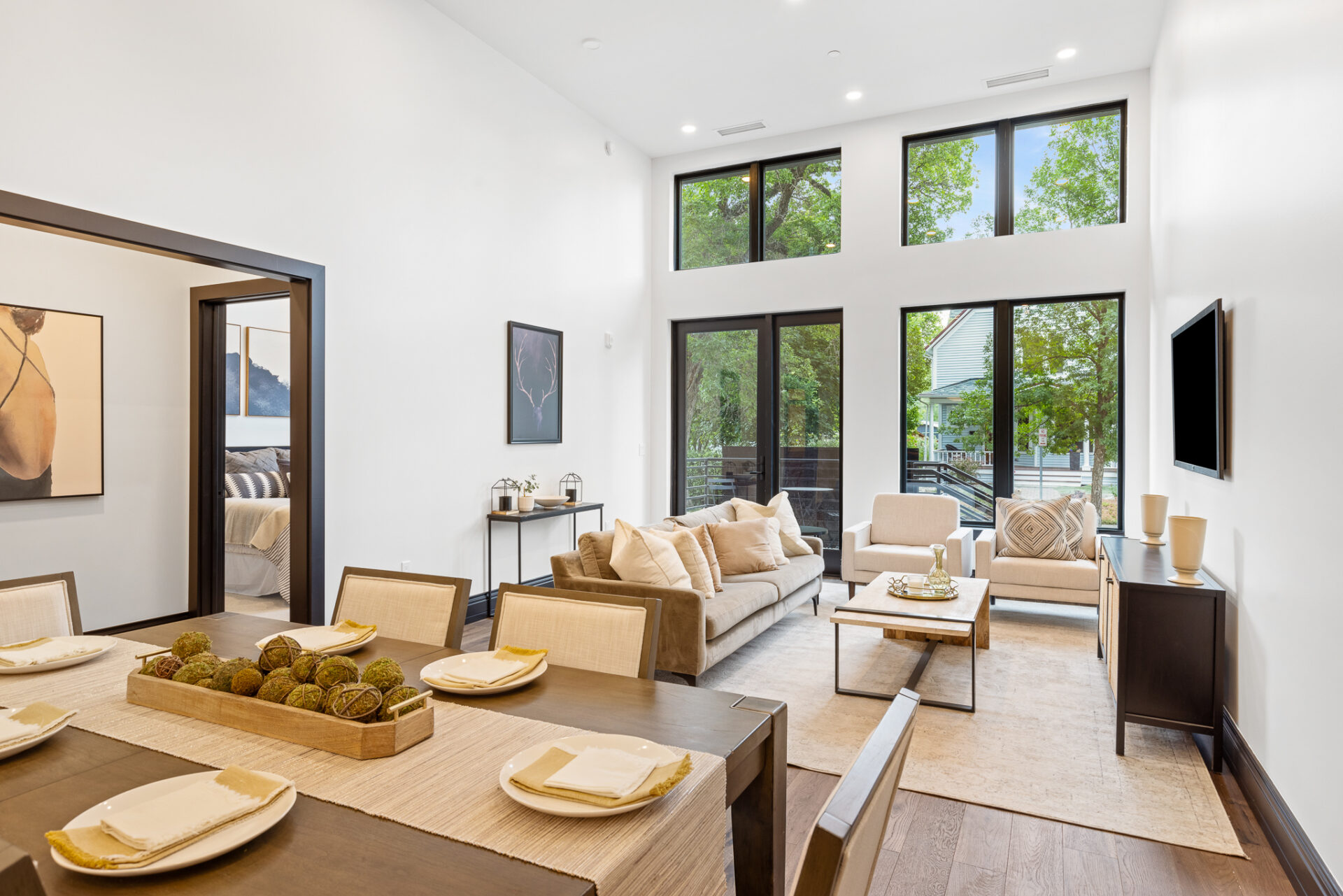 Spacious Bozeman Montana apartment at The Henry with double-height ceilings, hardwood floors, and open layout connecting dining, living, and bedroom