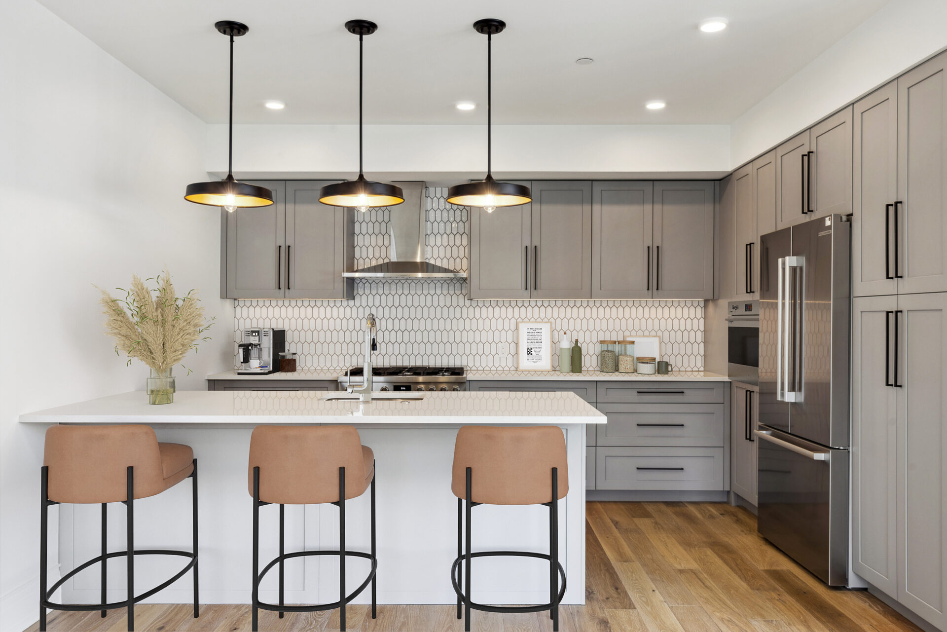 The Henry Bozeman Finish Package C white trim kitchen with custom gray cabinetry, quartz countertops, hexagon backsplash, and black hardware